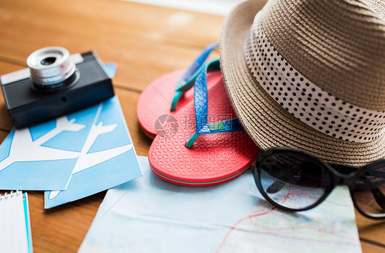 暑假,旅游物品旅行,拖鞋,帽子相机与飞机票家里的木桌上图片