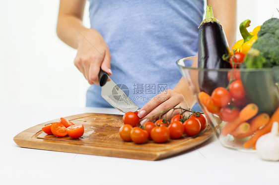 健康的饮食,烹饪,素食,饮食人的密切妇女切西红柿与刀砧板上图片