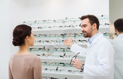 保健,人,视力视力眼镜师光学商店向妇女展示眼镜图片