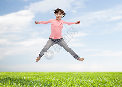 微笑天空幸福,童,自由,运动人的快乐的小女孩蓝天草地背景上跳跃背景