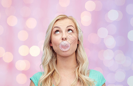 情感,表情人的快乐的轻女人十几岁的女孩嚼口香糖粉红色的节日灯光背景图片