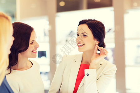 销售,消费主义,购物人们的快乐的快乐妇女选择尝试耳环珠宝店图片