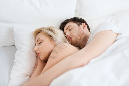 人,休息关系的幸福的夫妇睡家里的床上图片