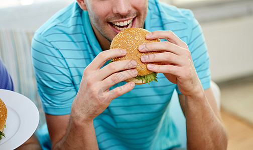 快餐,健康的饮食,人们垃圾食品接近快乐的人家里吃汉堡包图片