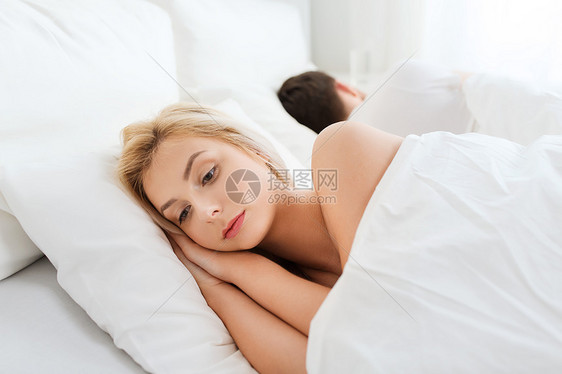 人,健康,睡眠障碍的夫妇背靠背躺家里的床上,轻的女人患失眠图片