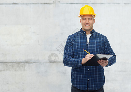 维修,建筑,人维修微笑的男建筑工人手工工人头盔与剪贴板记录灰色混凝土墙背景图片