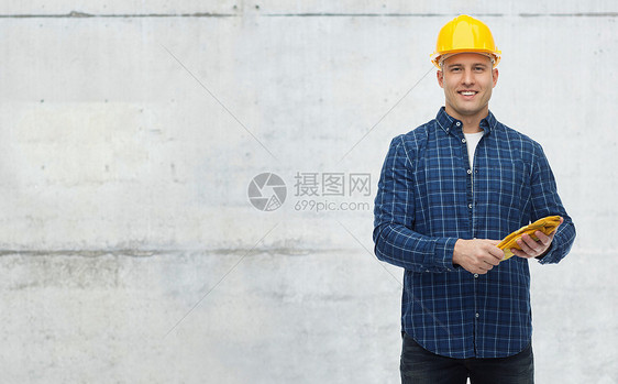 维修建筑施工人员维修理念戴着手套戴着头盔的微笑人,戴着灰色混凝土墙背景图片