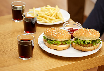 快餐,健康的饮食垃圾食品的汉堡包,饮料薯条家里的桌子上图片