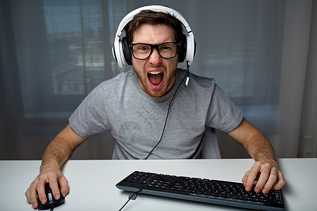 技术,游戏,娱乐活动,让39的游戏人的愤怒的尖叫轻人耳机与个人电脑电脑玩游戏家里流媒体播放演练视频图片