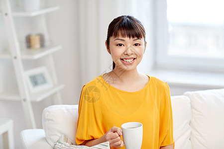人饮料休闲快乐的亚洲女人坐沙发上,家用杯子杯子喝茶图片