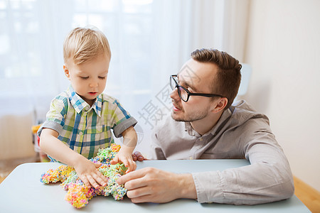 家庭,童,创造力,活动人的快乐的父亲小儿子家里玩球粘土图片