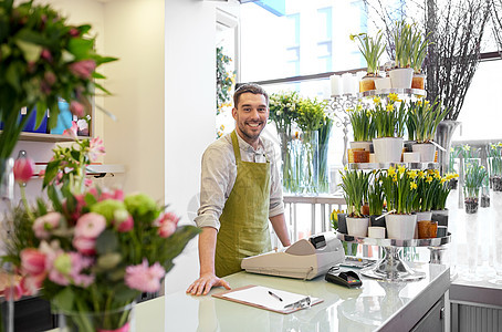 人,销售,零售,商业花卉快乐微笑的花店男子与剪贴板现金箱站花店柜台图片