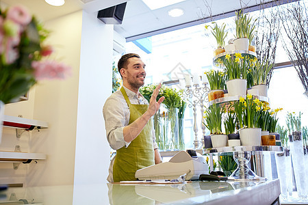 人,销售,零售,商业花卉快乐微笑的花店男子与现金箱站花店柜台图片