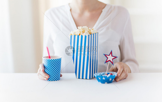 美国独立日,庆祝,主义节日的妇女吃爆米花与饮料糖果7月4日的聚会图片