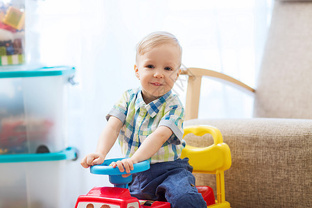 童,玩具人的快乐的小男孩驾驶玩具汽车家里图片