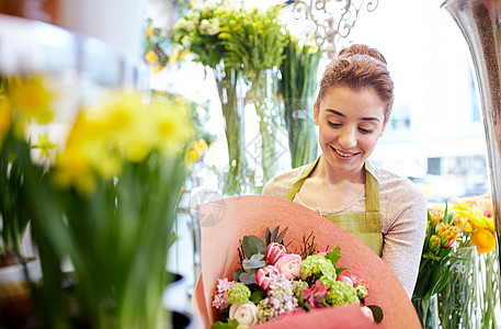 人,商业,销售花艺的快乐微笑的花店着花包成纸花店图片