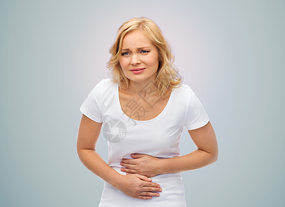 人,医疗保健问题快乐的女人患胃痛的灰色背景图片
