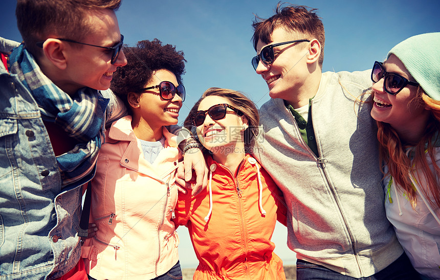旅游,人,休闲青少的群快乐的朋友戴着太阳镜城市街道上拥抱欢笑图片