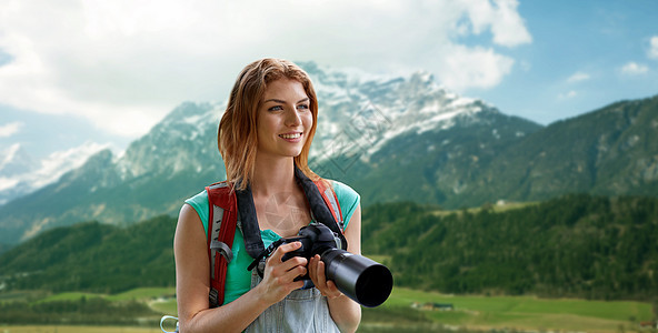 冒险,旅行,旅游,徒步旅行人们的快乐的轻女人背包相机拍摄阿尔卑斯山的背景图片