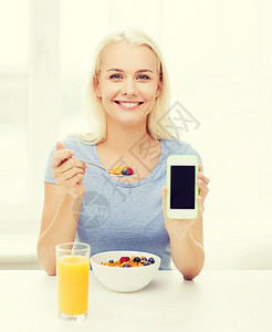 健康的饮食,饮食人的微笑的轻妇女与平板电脑吃早餐空白的智能手机屏幕家里图片