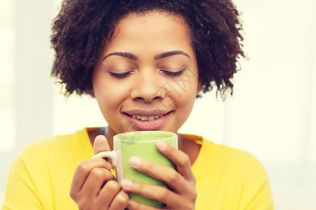 人,饮料休闲快乐的非裔美国妇女喝茶杯子杯子家里图片