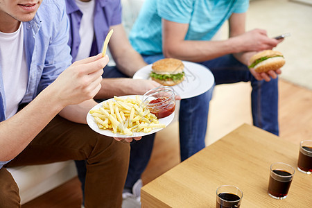 快餐,健康的饮食,人垃圾食品亲密的快乐朋友家里吃炸薯条汉堡包图片