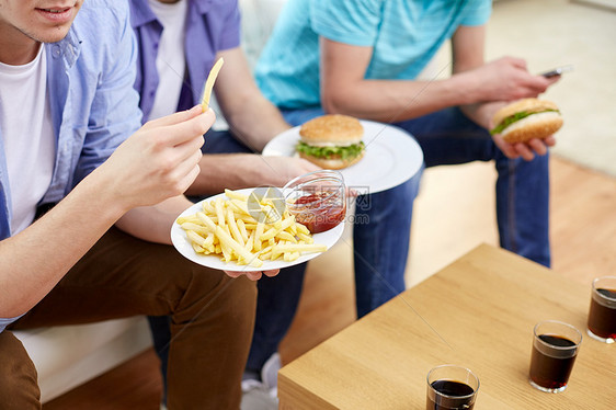 快餐,健康的饮食,人垃圾食品亲密的快乐朋友家里吃炸薯条汉堡包图片