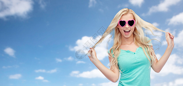 情感,表情,夏天人的微笑的轻女人十几岁的女孩戴着她的头发蓝天云彩的背景上图片