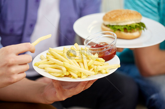 快餐,健康的饮食,人垃圾食品用炸薯条,番茄酱汉堡包盘子里靠近男的手图片