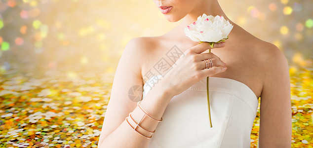 魅力,美丽,珠宝豪华美丽的女人与金戒指手镯举行花黄金假日灯光背景图片
