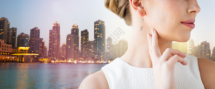 魅力,美丽,珠宝豪华美丽的女人脸与黄金钻石耳环新加坡城市摩天大楼的背景图片