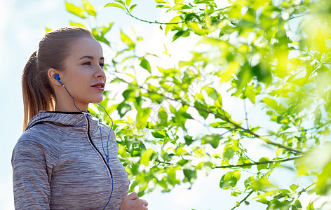 健身,运动,人,技术生活方式的快乐的女人跑步听音乐耳机绿色自然背景图片