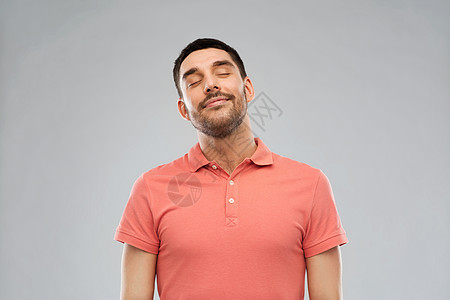 情感人的笑男人马球T恤灰色背景灰色背景上的笑男图片