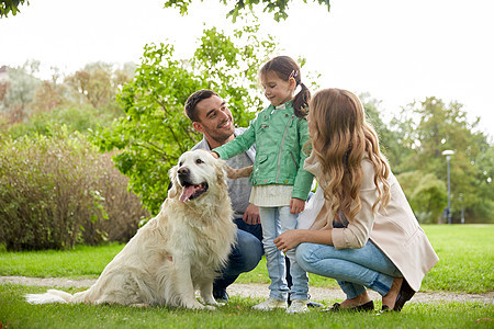 家庭,宠物,家畜人的快乐的家庭与拉布拉多猎犬公园散步图片