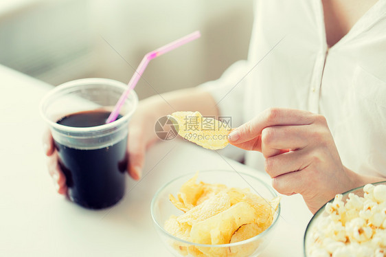 人们,快餐,垃圾食品健康的饮食观念密切妇女与爆米花,玉米片玉米薯片花生碗里图片