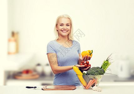 健康的饮食,烹饪,素食,饮食人们的微笑的轻妇女与碗蔬菜家庭厨房背景图片
