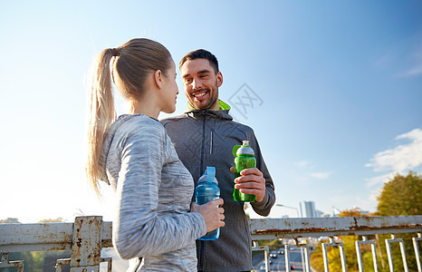 健身,运动,友谊生活方式的微笑夫妇与瓶装水户外图片