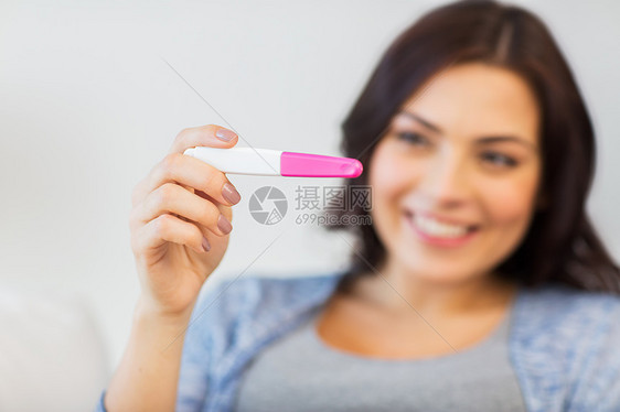 怀孕,生育,生育人的亲密的快乐微笑的女人家里看怀孕测试图片