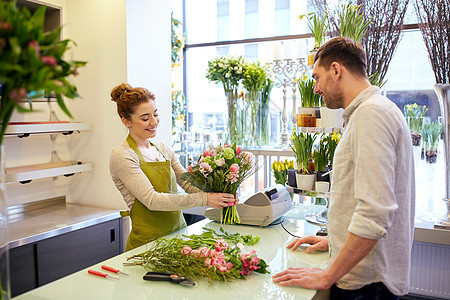 人,购物,销售,花卉消费观念快乐微笑的花店妇女为男人顾客制作花图片