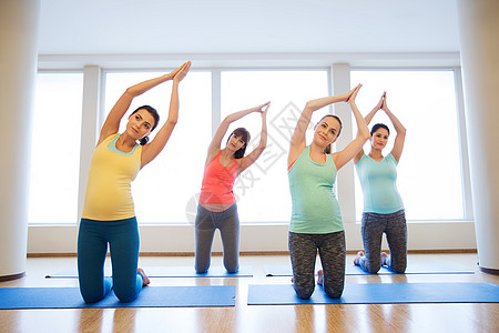 怀孕,运动,健身,人健康的生活方式群快乐的孕妇健身房的垫子上锻炼图片