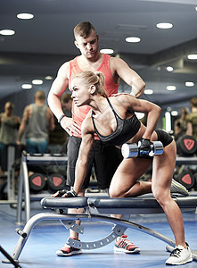 健身,运动,锻炼,健美举重的轻妇女私人教练与哑铃弯曲肌肉健身房图片