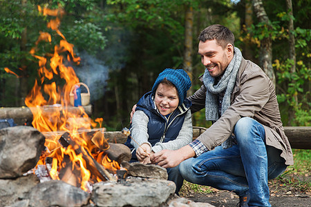 野营,旅游,远足,家庭人的快乐的父亲儿子烤棉花糖超过篝火图片