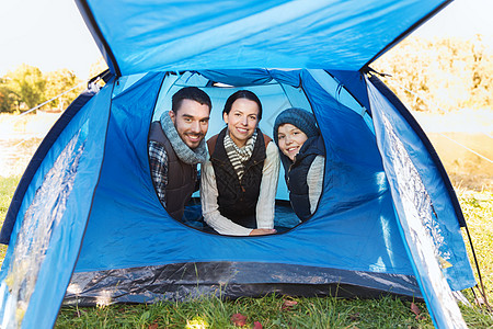 露营,旅游,徒步旅行人们的快乐的家庭帐篷内的营地图片
