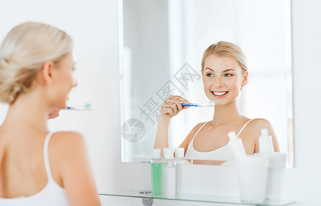 保健,牙科卫生,人与美的微笑的轻妇女牙刷,清洁牙齿,并家里的浴室看镜子图片