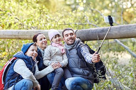 旅行,旅游,徒步旅行,技术人的快乐的家庭与背包拍摄智能手机自拍棒树林图片
