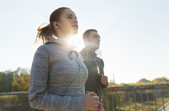 健身,运动,人生活方式的快乐的夫妇与耳机运行户外图片