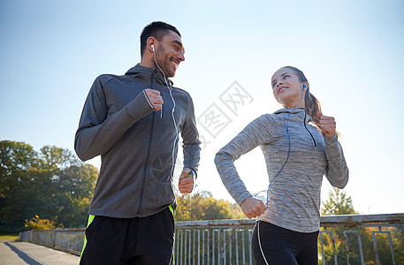 健身,运动,人生活方式的快乐的夫妇与耳机运行户外图片