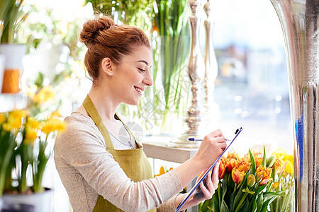 人,销售,零售,商业花卉快乐微笑的花店妇女与剪贴板写作笔记订单花店图片