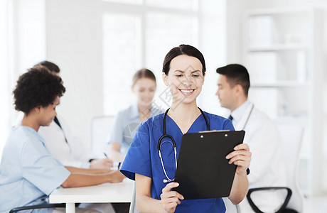 诊所,职业,人医学的快乐的女医生与剪贴板超过医疗会议医院图片