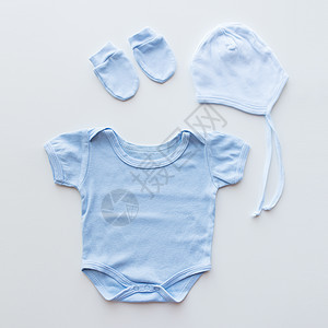 婴儿服装,婴儿,母亲象蓝色紧身衣,帽子手套为新生男孩桌子上图片